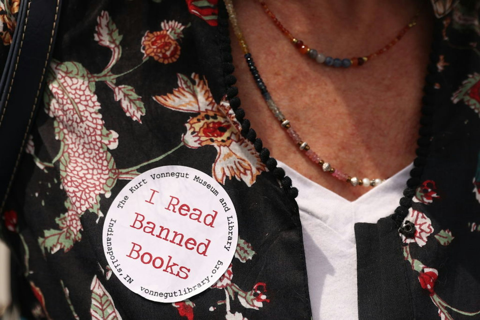 A closeup of a woman's shirt with a sticker affixed to it.