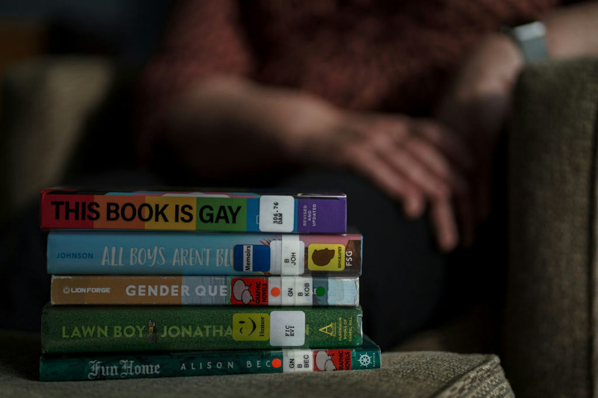 A stack of five books on a table with colorful spines.