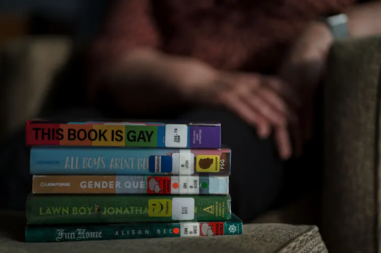 A stack of five books on a table with colorful spines.