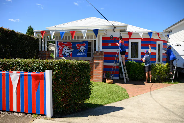 Locals paint the exterior of their home in Knights colours ahead of the Grand Final.