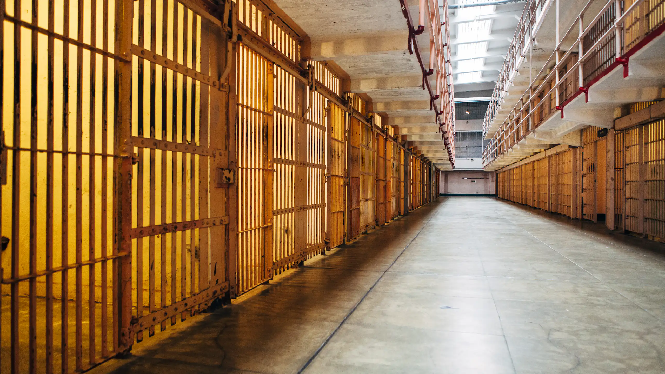 A long walkway between prison cells.