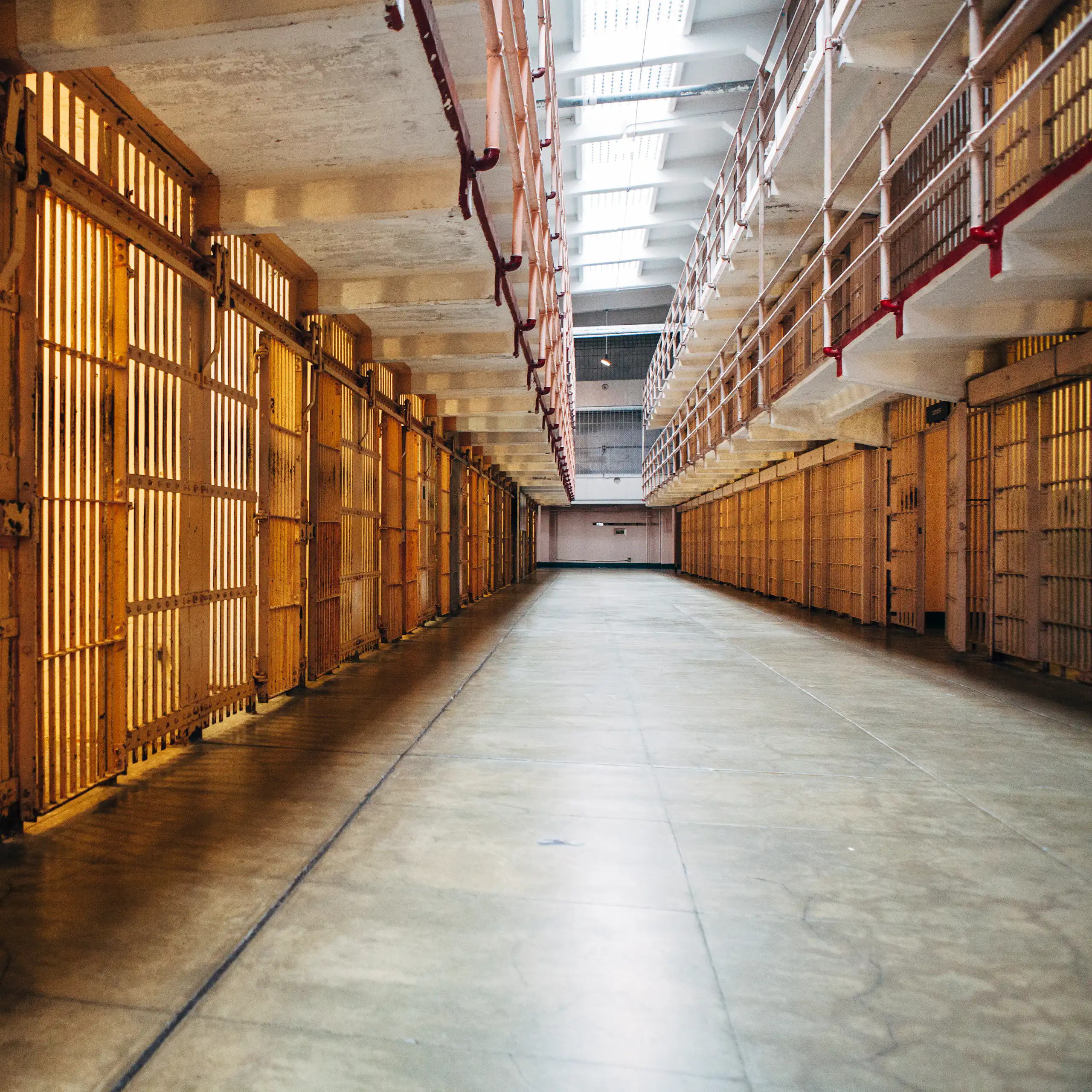 A long walkway between prison cells.