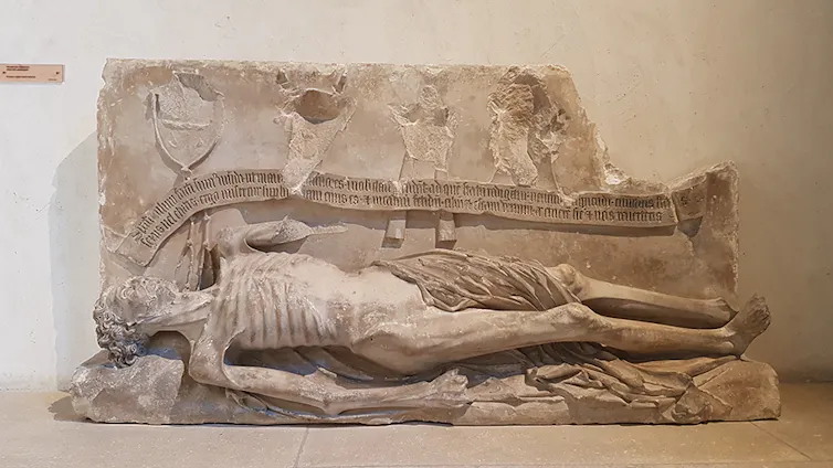 Sepulcro del cardenal Jean de la Grange que representa el esqueleto de un hombre bajo tierra.