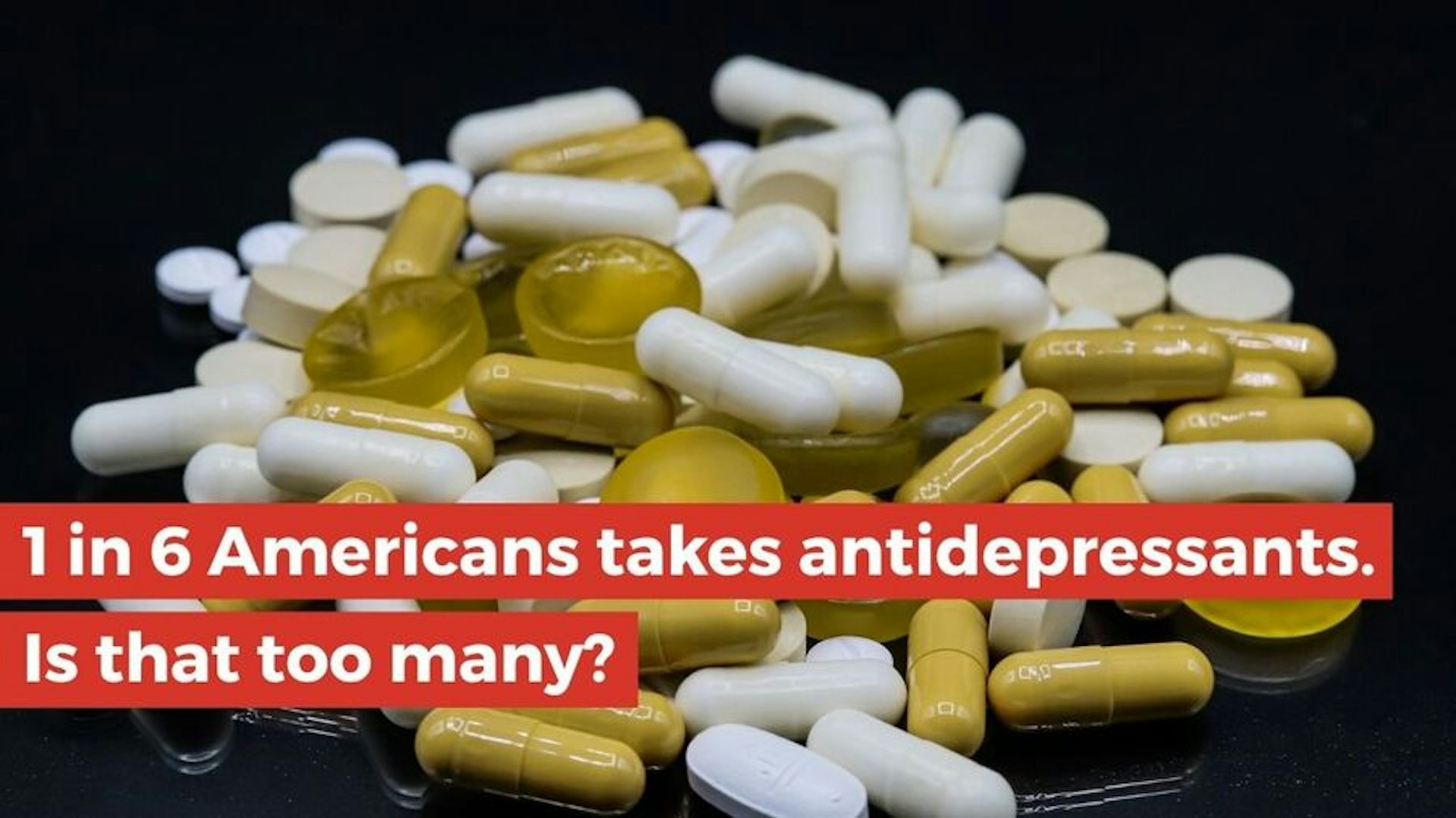 This is a pile of white and green pills on a black background.