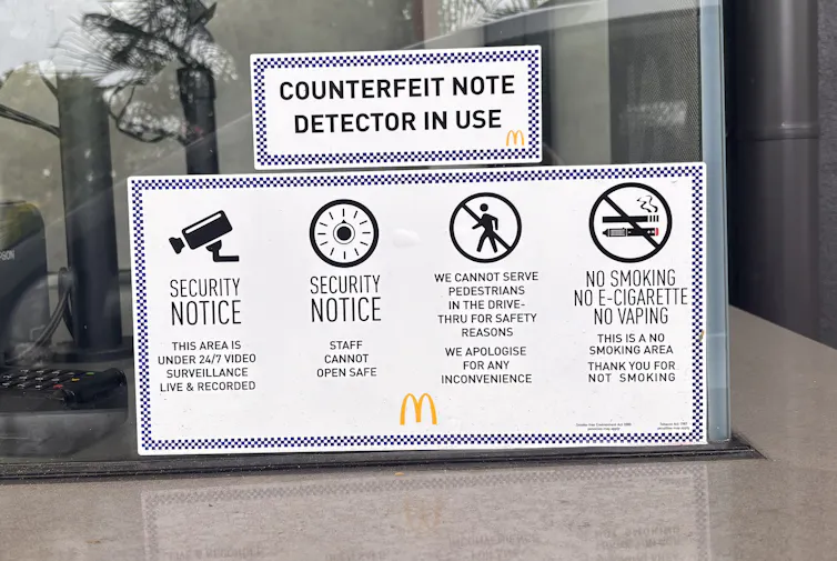 A sign at a McDonalds drive through in suburban Brisbane saying Counterfeit note detectors in use