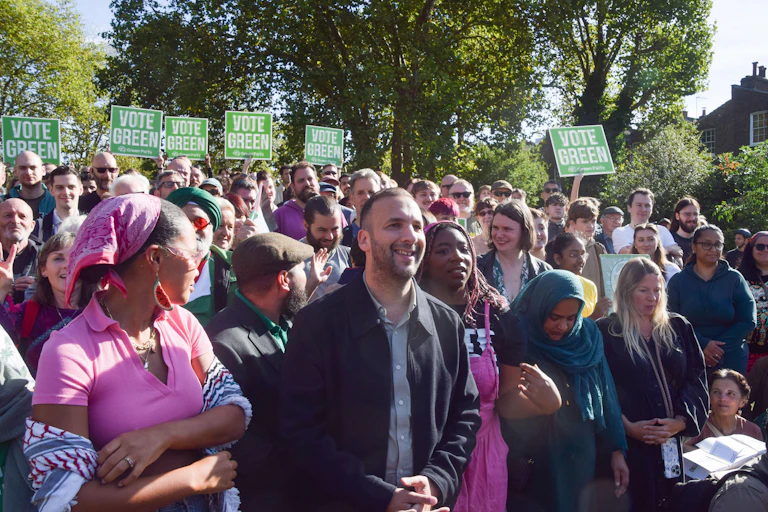 green party leader zack polanski with supporters holding vote green placards in london.