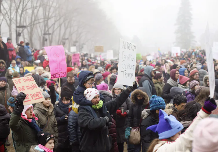 A crowd of anti-Trump, pro-women's march demonstrators. A lone protester carries a pro-Trump sign.