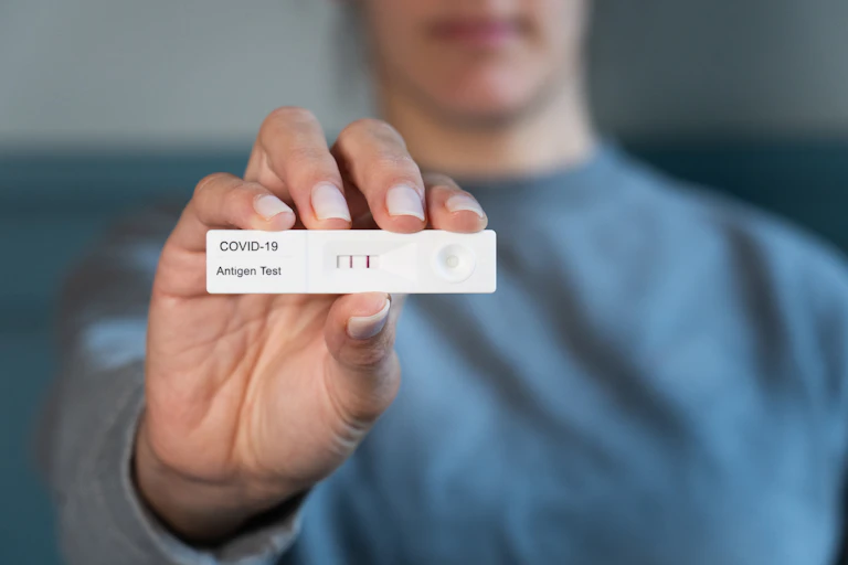 Una mujer muestra el resultado positivo de una prueba de covid
