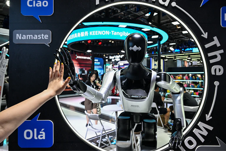 Une femme touche la main du robot.