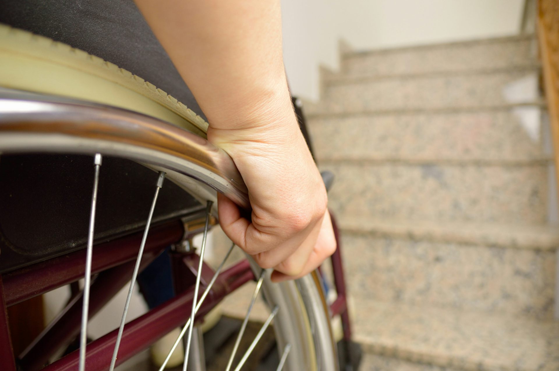 A person in a wheelchair at the bottom of some steps