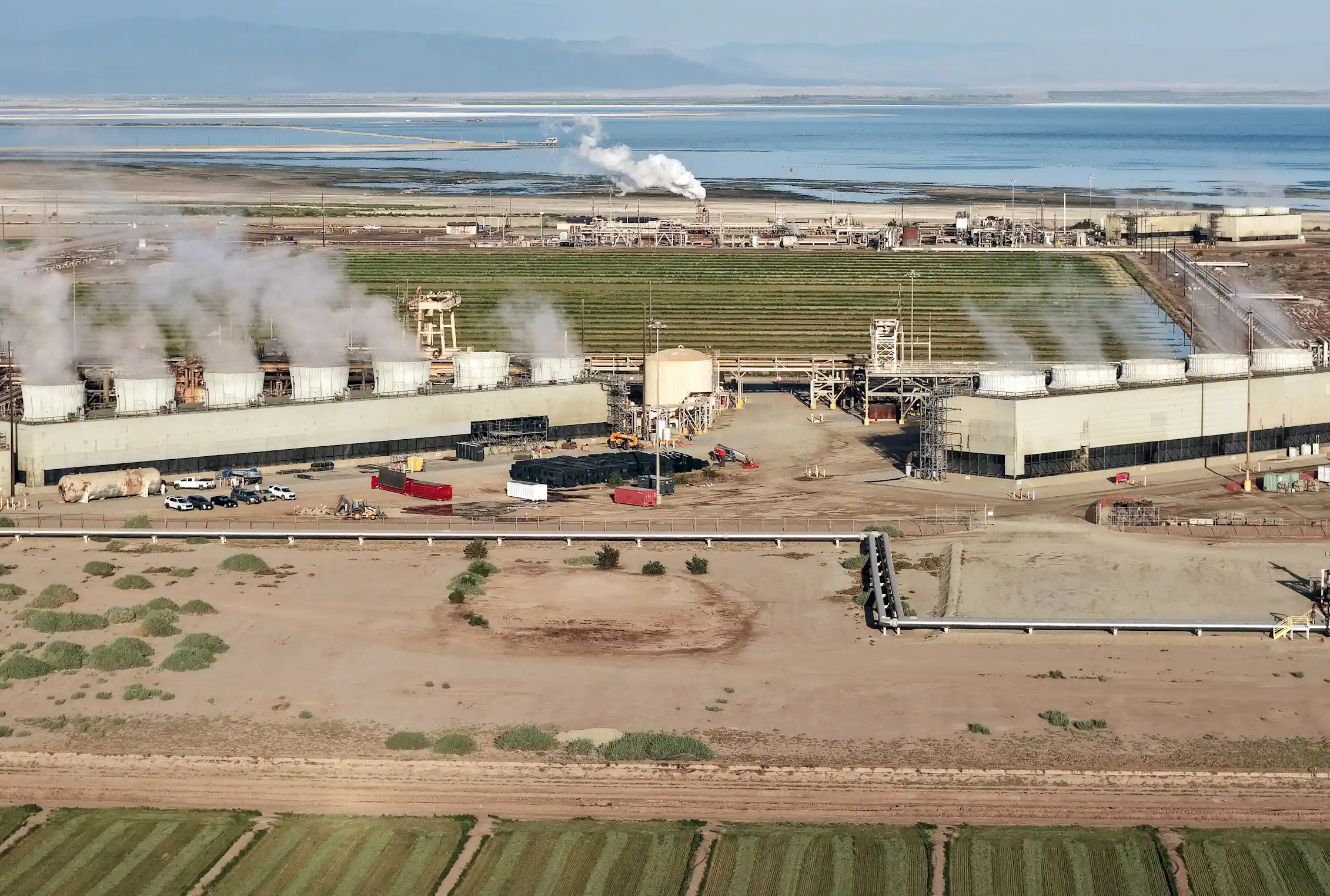 A large industrial area with concrete towers emitting steam.