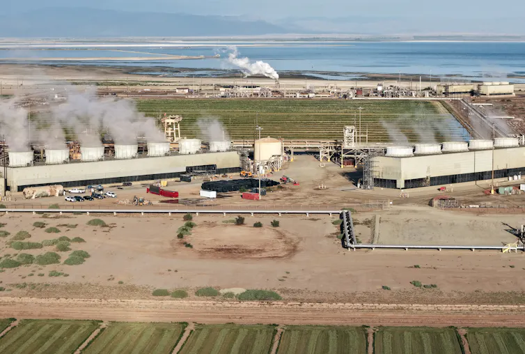 A large industrial area with concrete towers emitting steam.