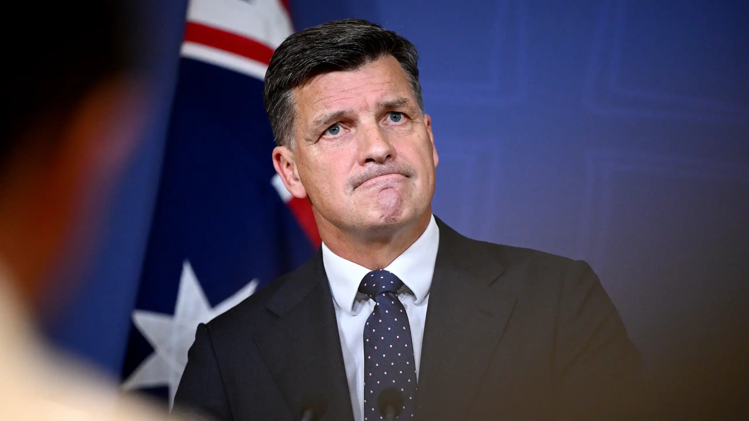 Angus Taylor grimaces in the middle of a press conference