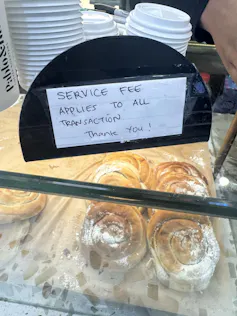 A sign in the cafe for a new service fee