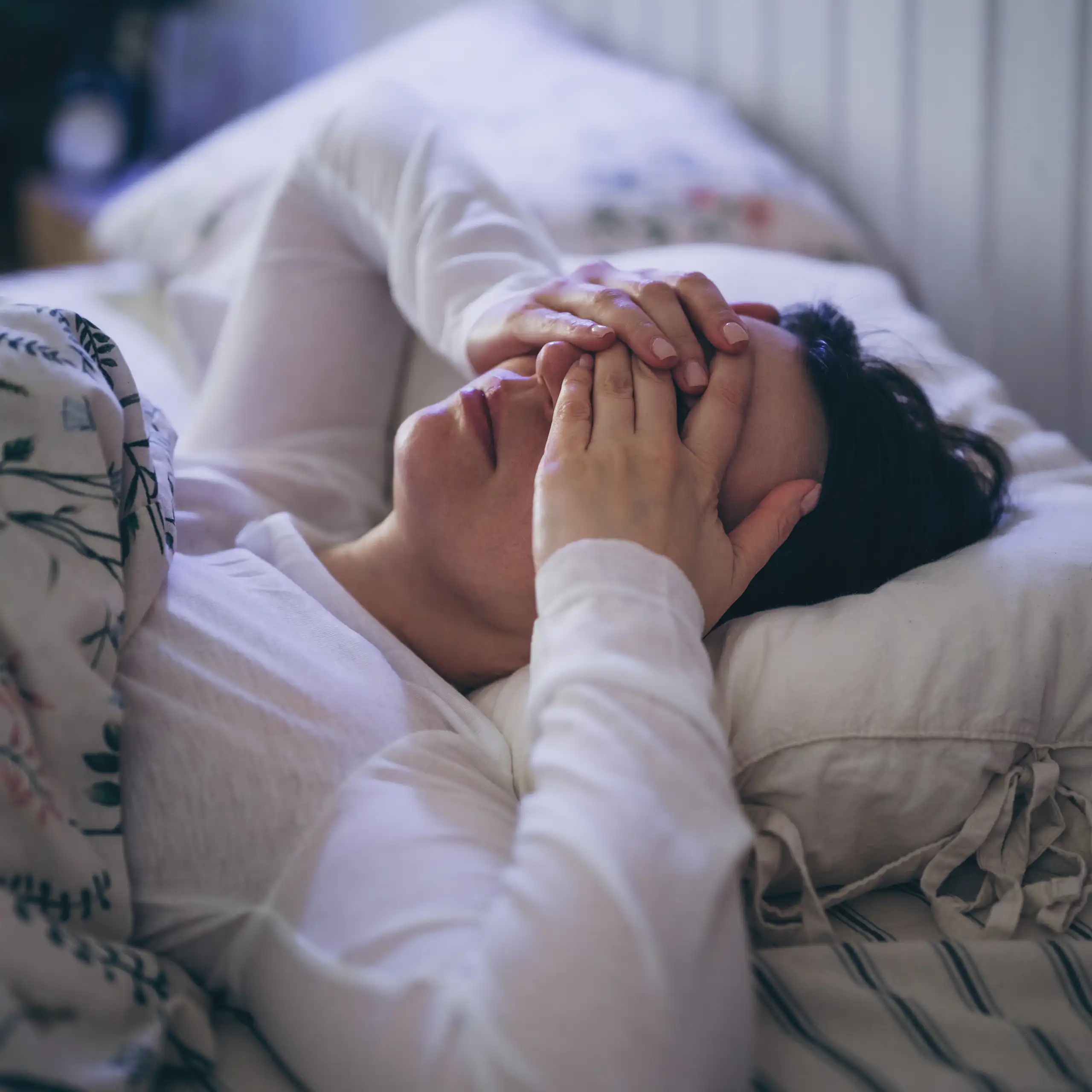 A woman shields her eyes after a bad night's sleep