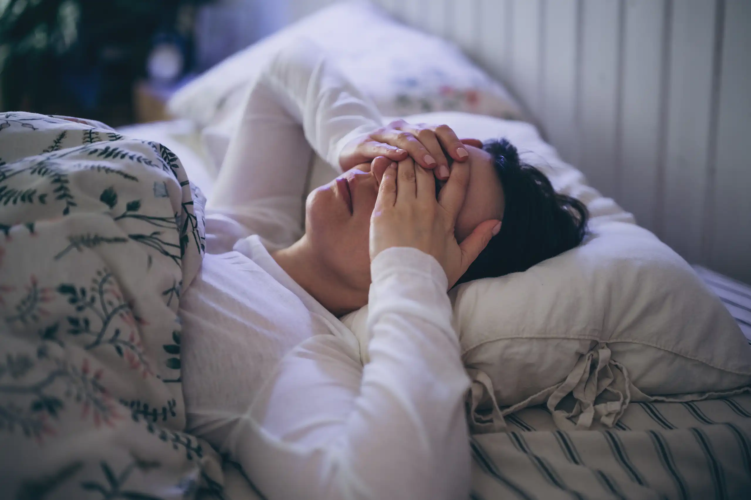 A woman shields her eyes after a bad night's sleep