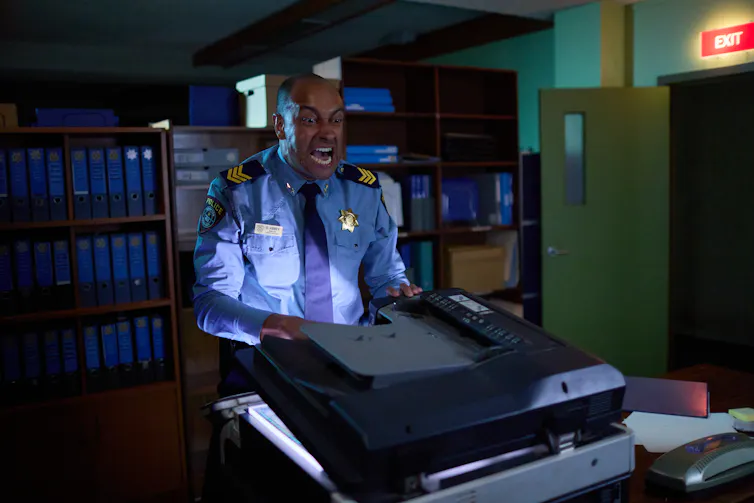 Matt Okine fights with a photocopier.
