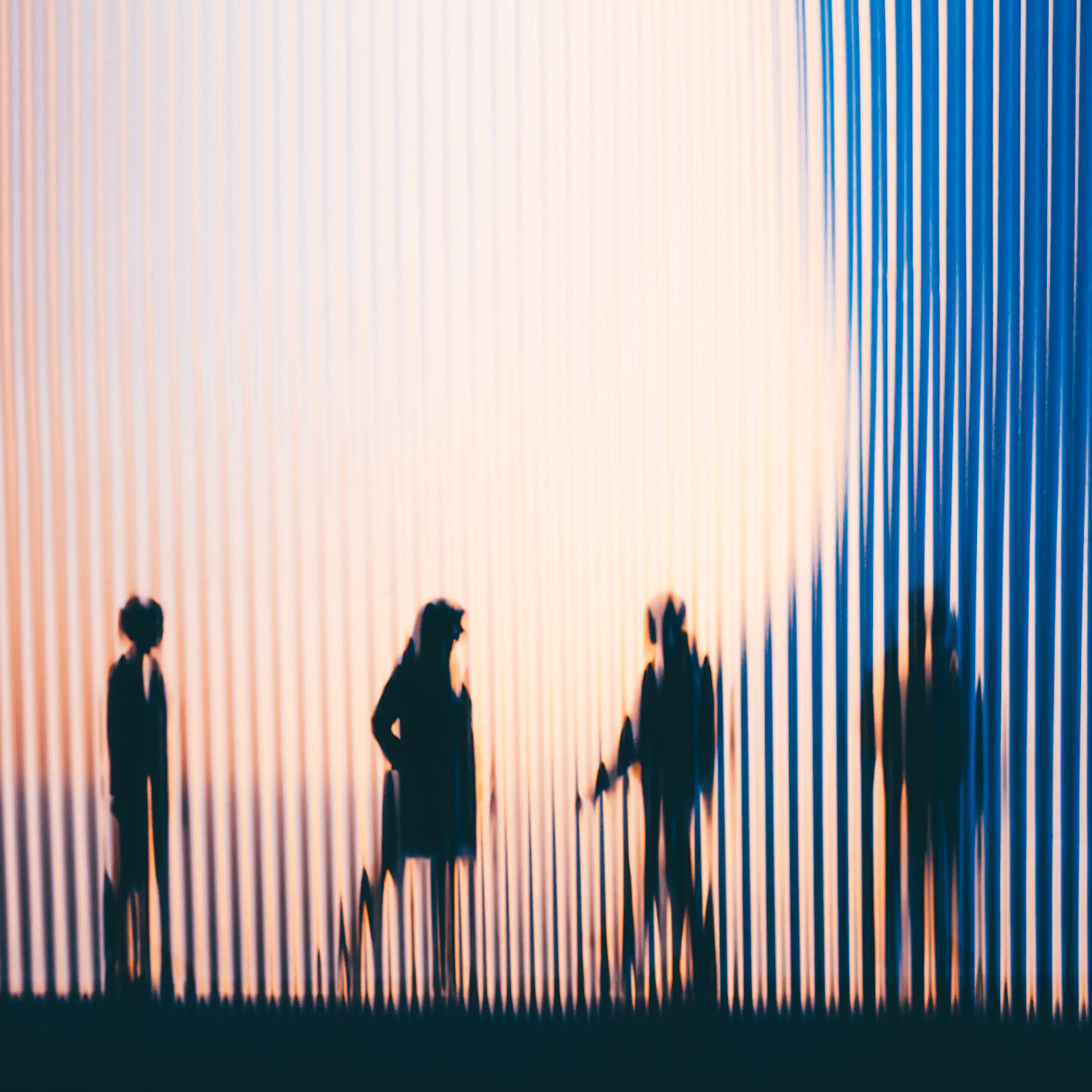 A sseries of silhouetted people behind fluted glass.