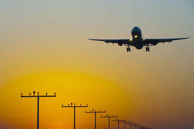 An aircraft landing at sunrise.