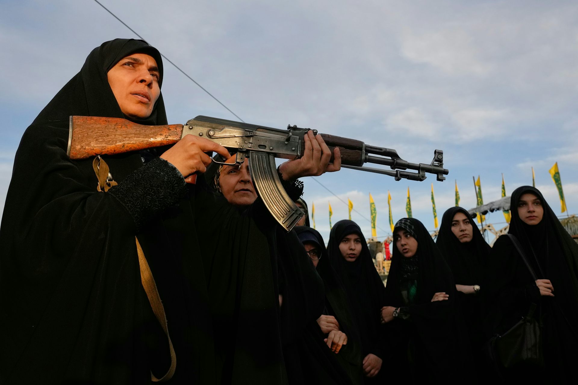 A woman in a niqab holds an assault rifle.