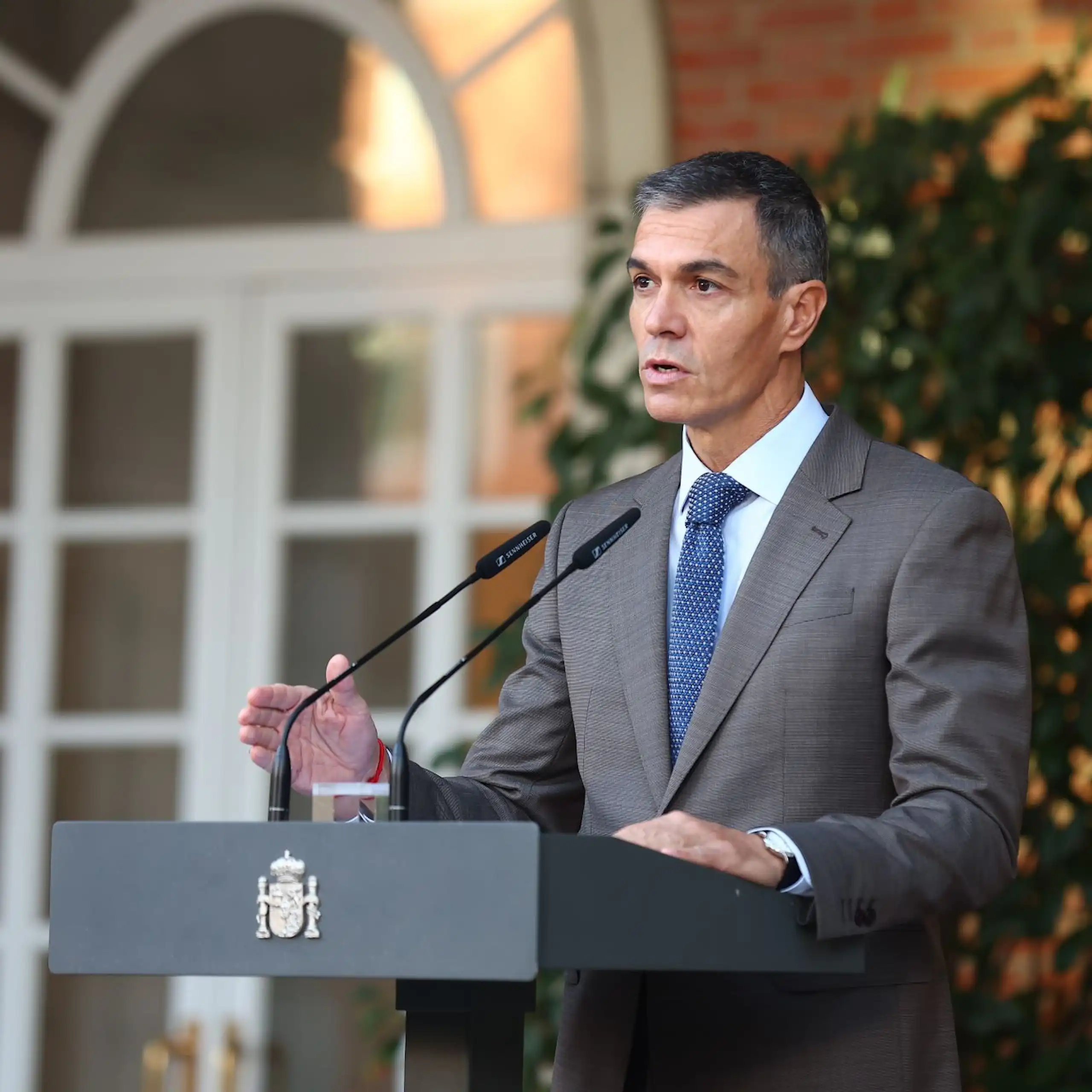 Pedro Sánchez speaking into a microphone on a lectern.