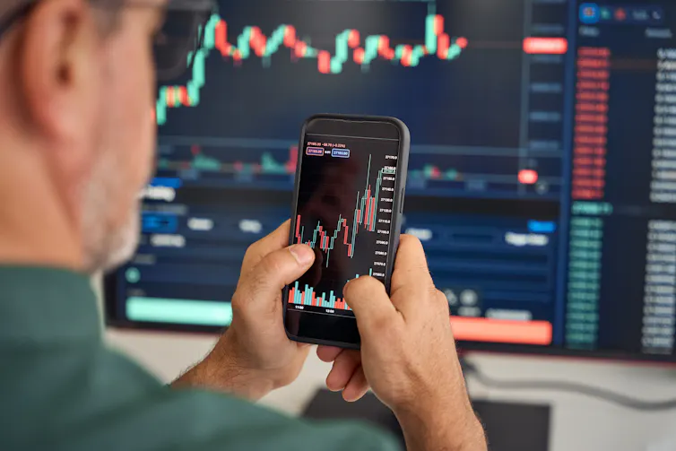 Man analysing shares on a mobile phone.