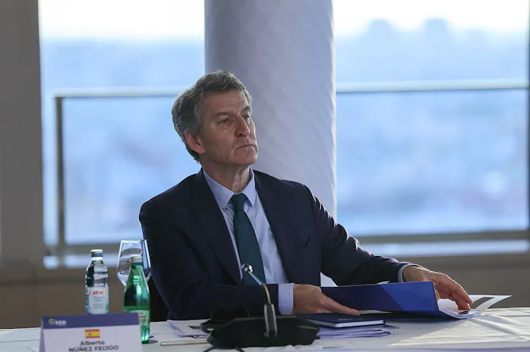 A man in a suit sits at a table.