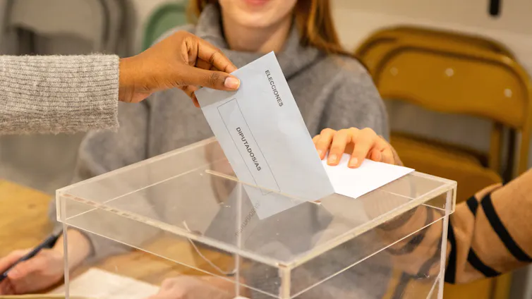 Mano depositando el voto en una urna