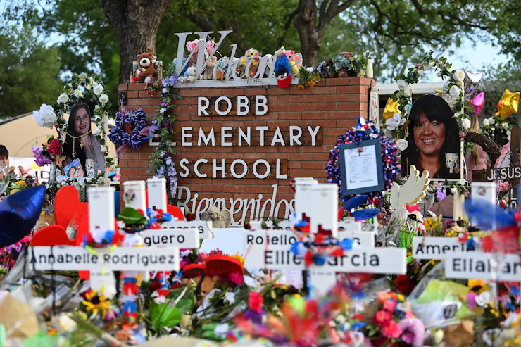 A makeshift shrine adorns the sign of an elementary school.