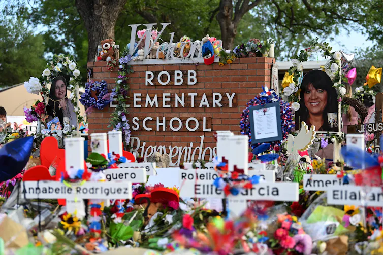 A makeshift shrine adorns the sign of an elementary school.