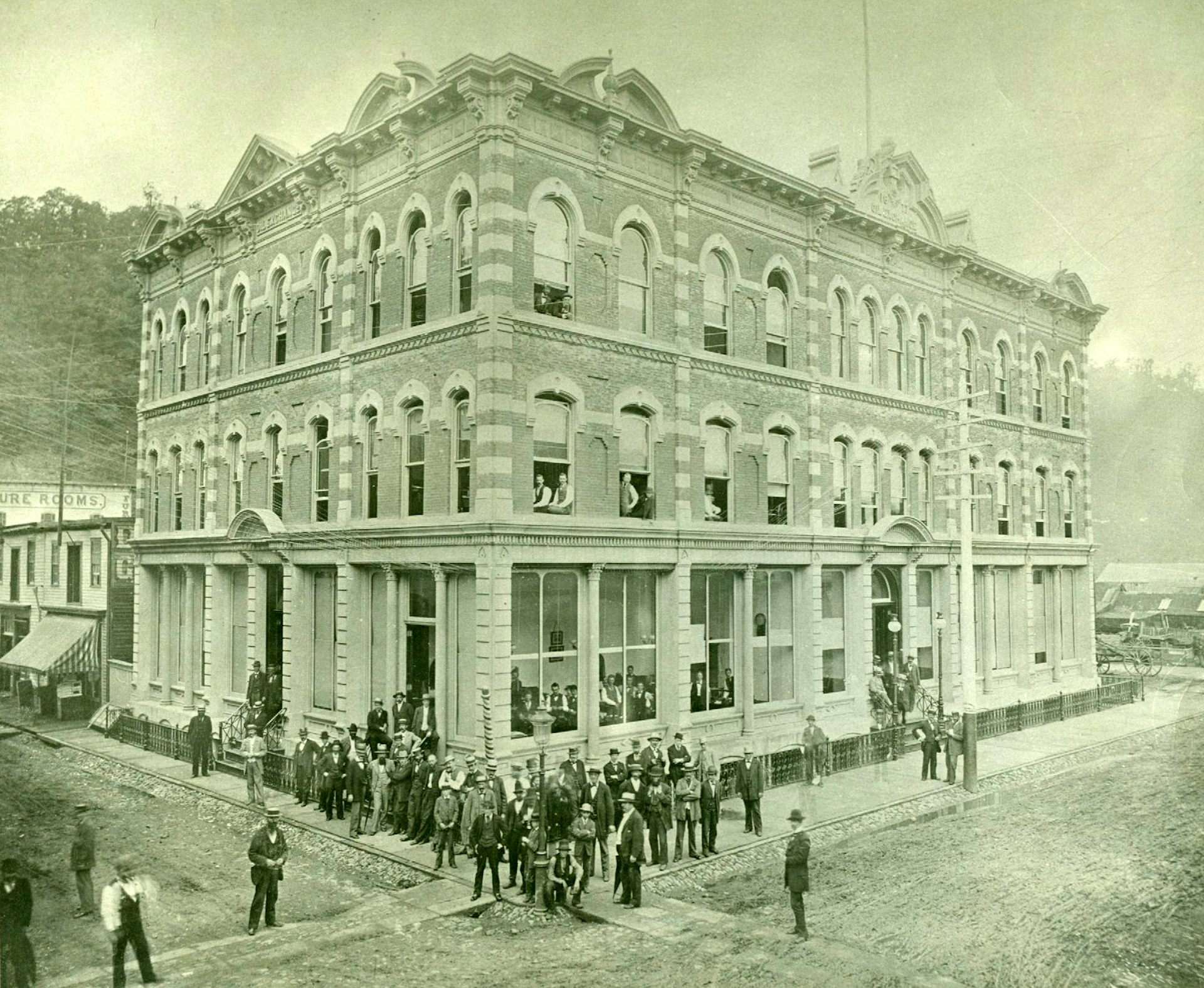Businessmen are seen outside an ornate building in a black-and-white photo.