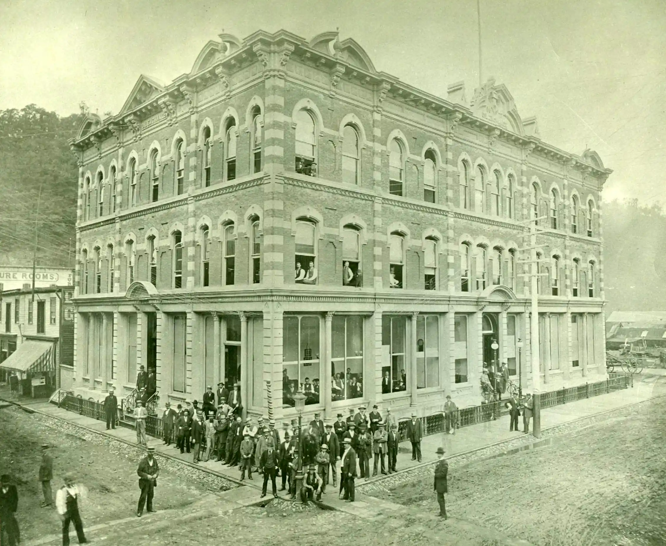 Businessmen are seen outside an ornate building in a black-and-white photo.