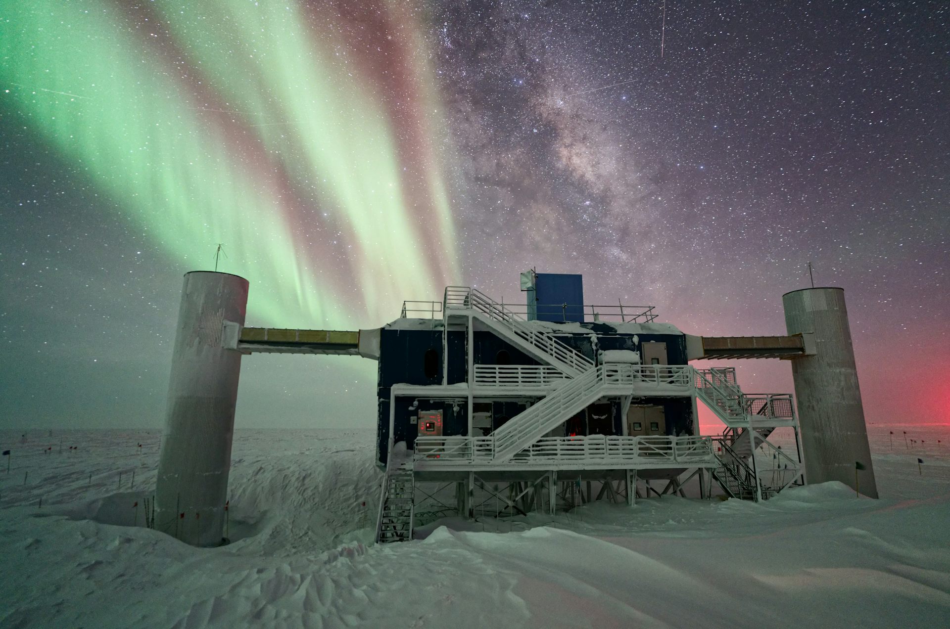 De nit, una gran estructura sobre la neu, amb aurores boreals i moltes estreles al cel.