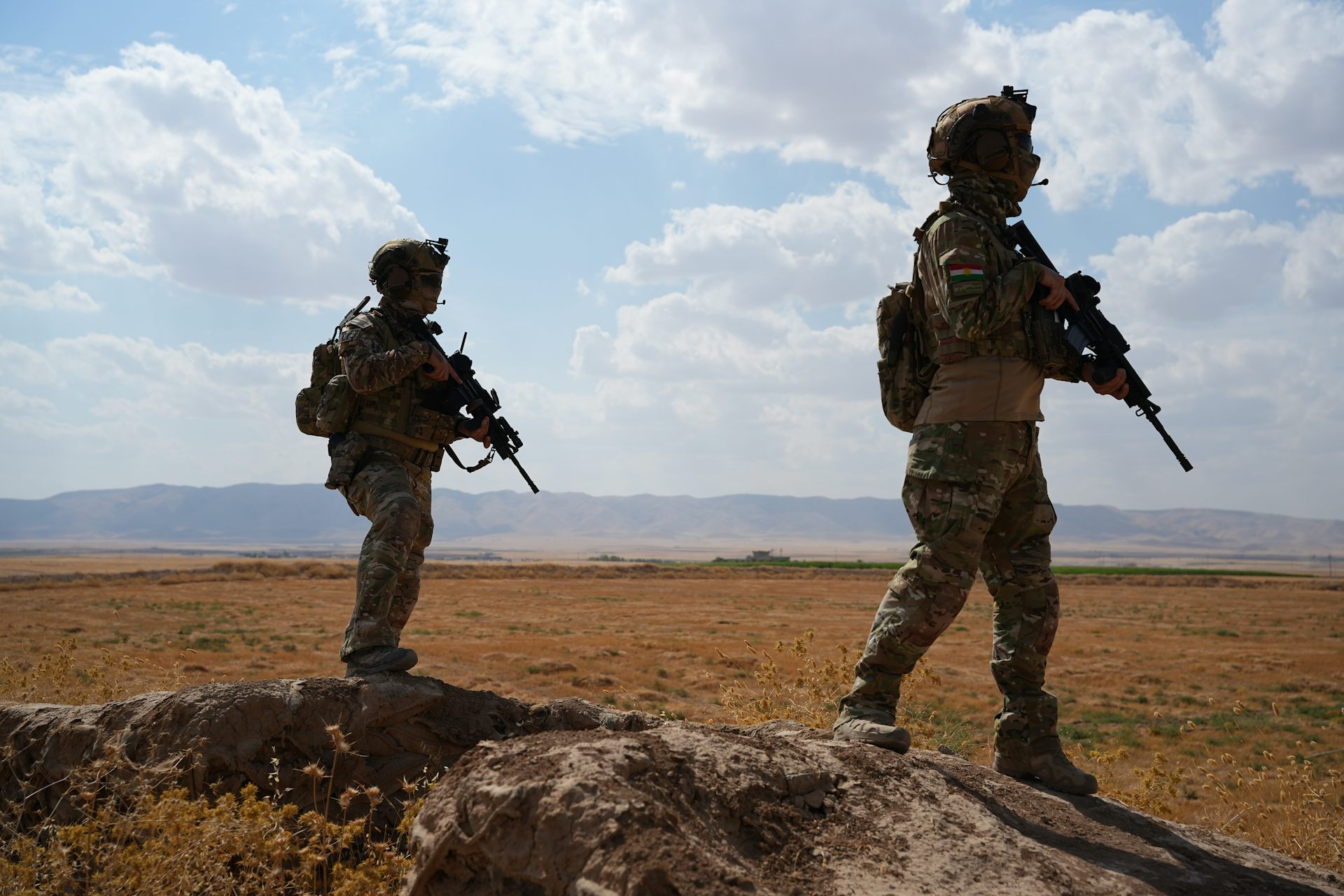 Two soldiers on patrol in the countryside.