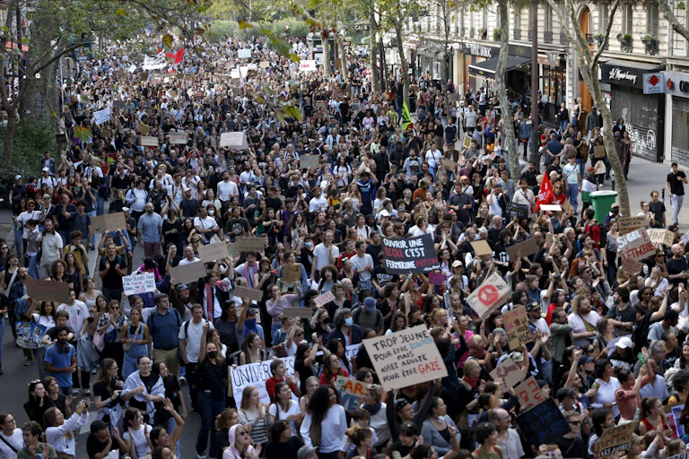 A Paris street full of protesters carryng banners