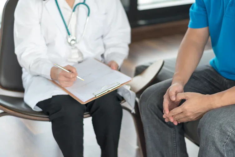 Doctor sitting with male patient