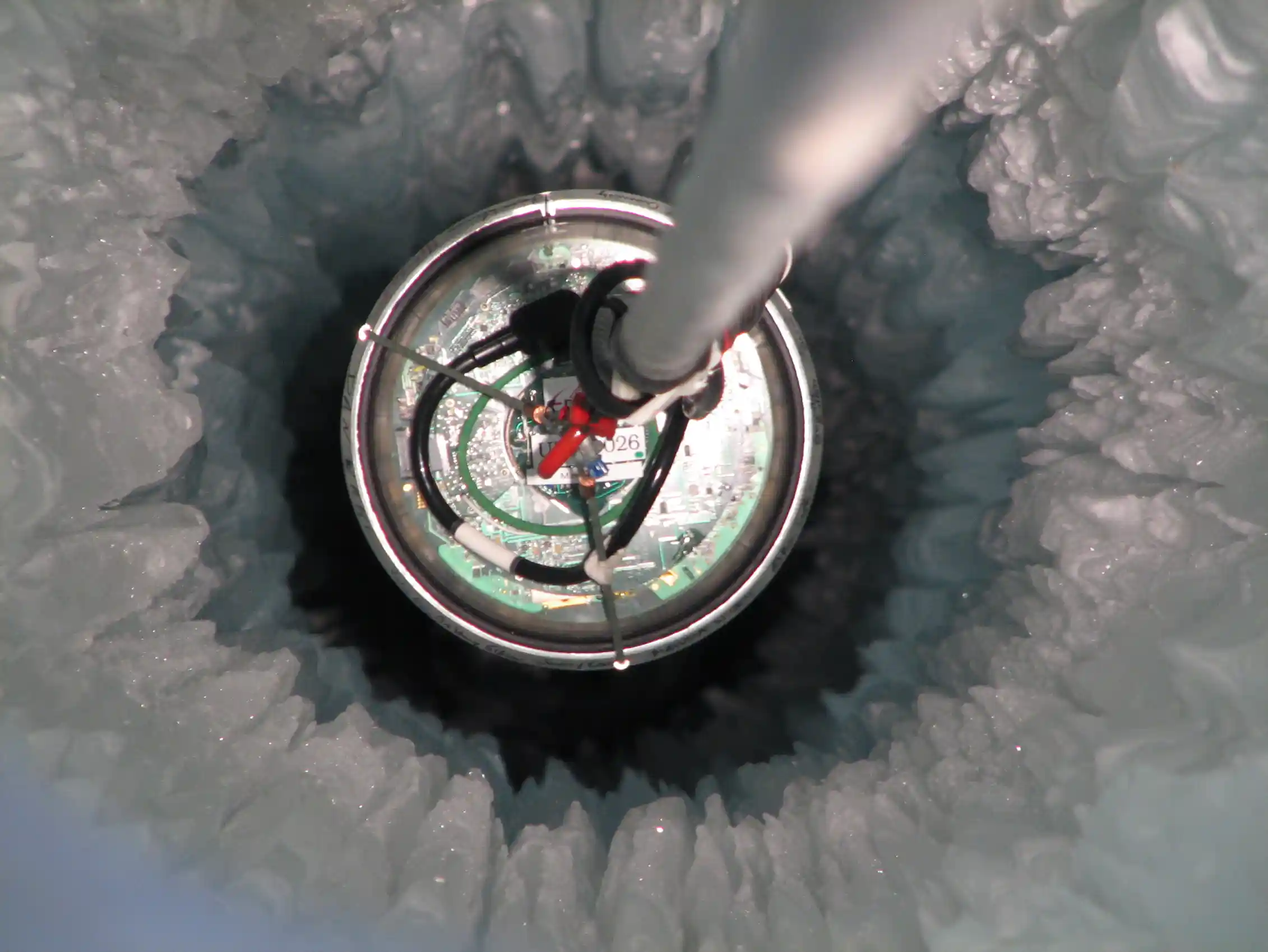 A metal rod stuck into a deep hole in the ice