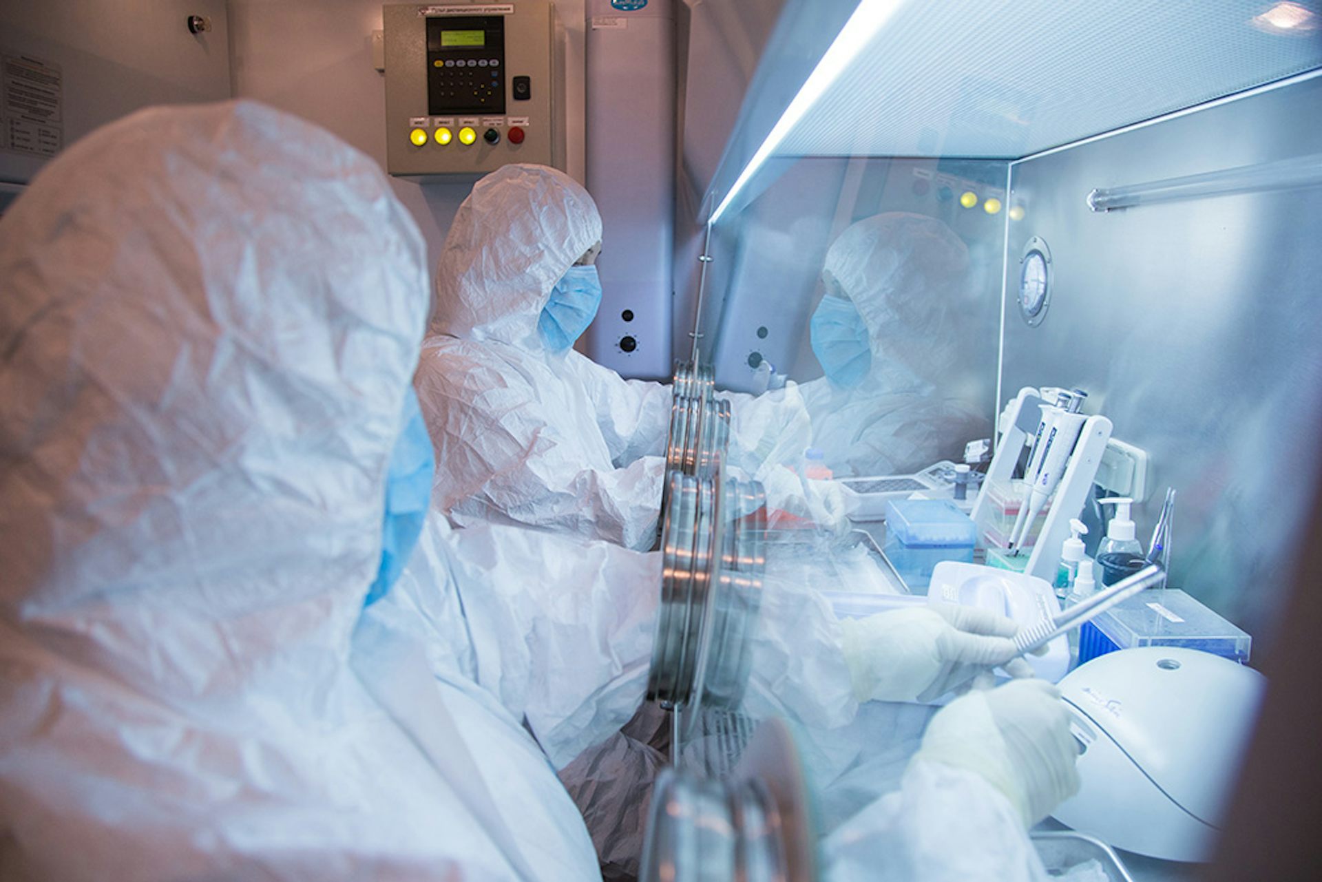 Imagem de laboratório com pessoas usando roupas de proteção biológica 