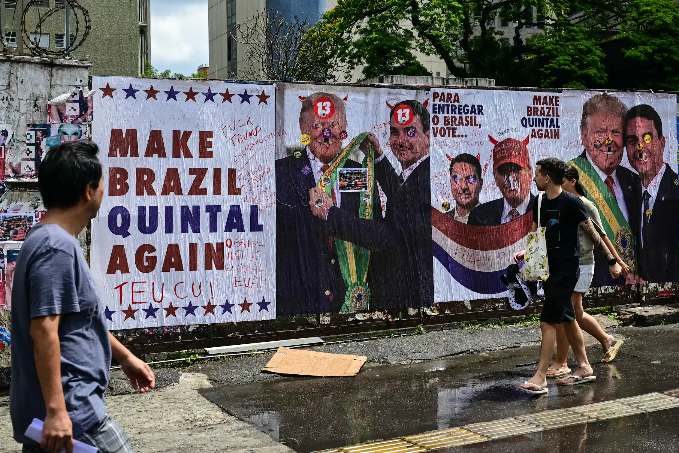 people walking by a mural with pictures of two men together