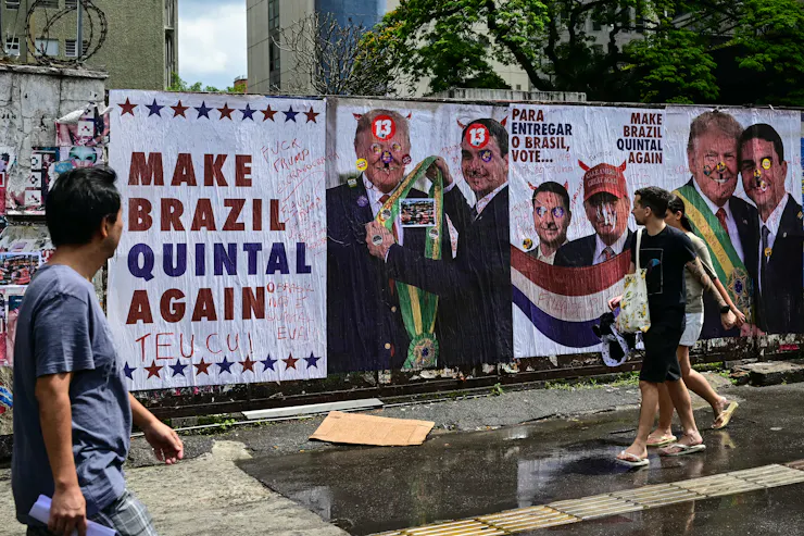 people walking by a mural with pictures of two men together