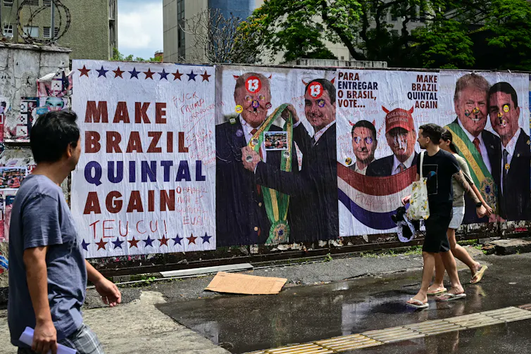 people walking by a mural with pictures of two men together
