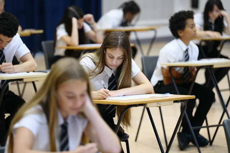 High school students sitting an exam, looking focused.