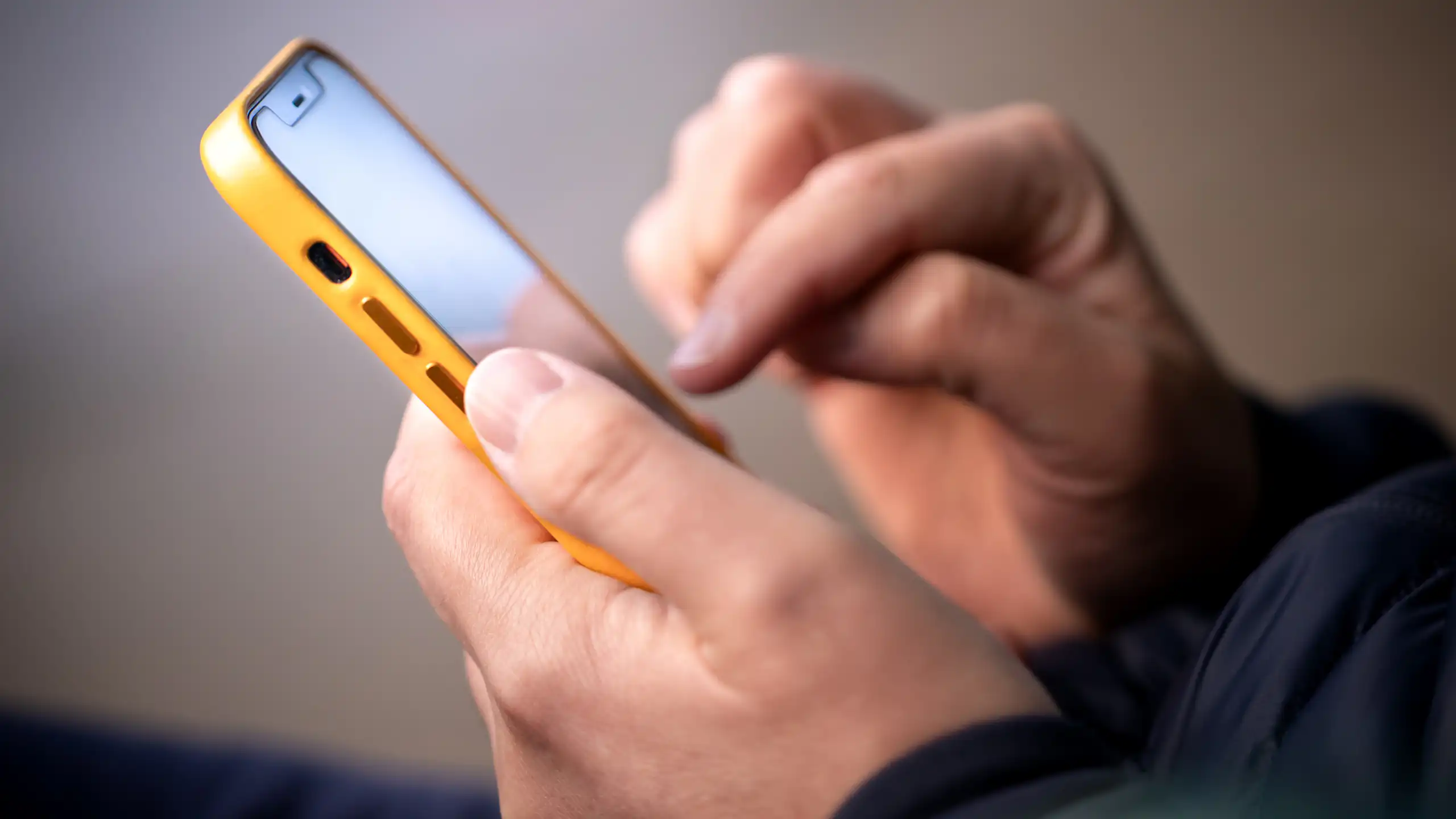 Person holding yellow iphone.