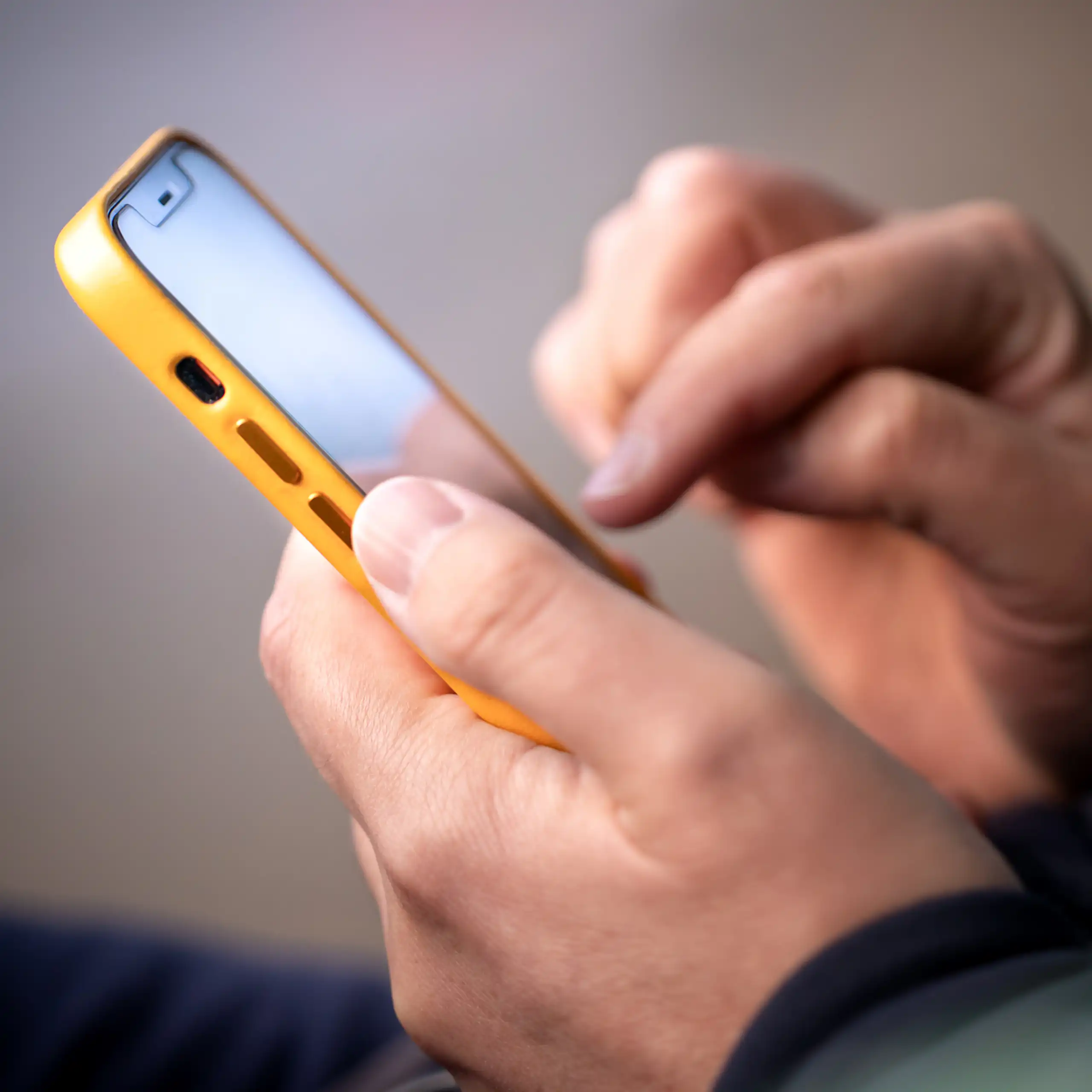 Person holding yellow iphone.