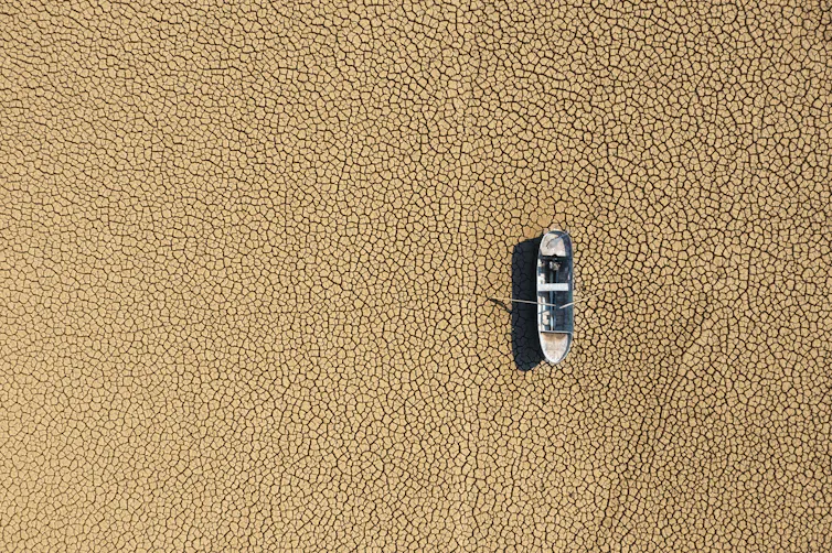 boat high and dry on lake bed.