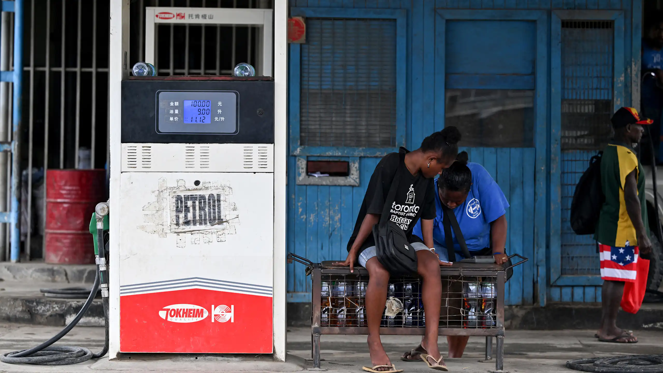 Two workers wait for customers at a petrol station in Honiara, the Solomon Islands capital.