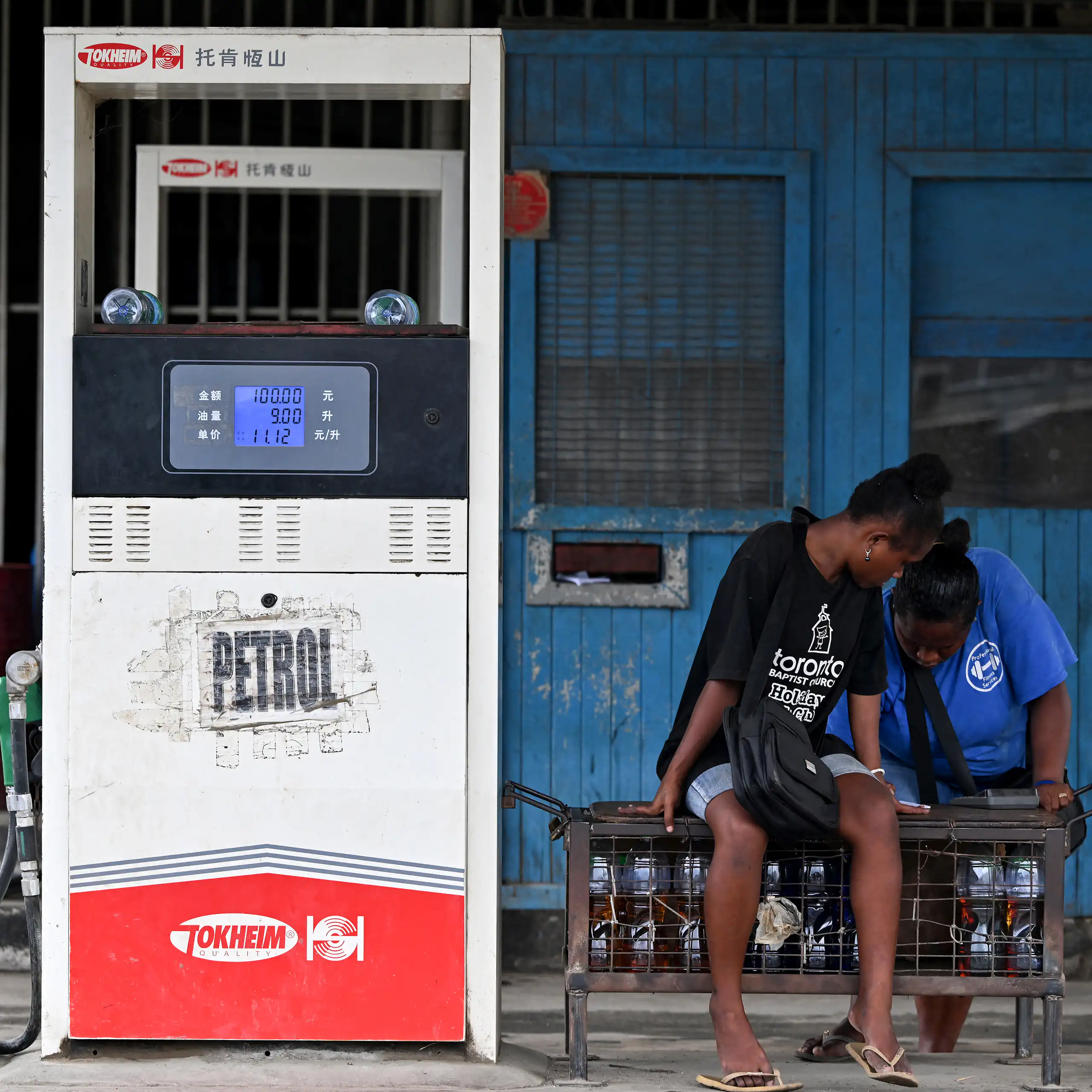 Two workers wait for customers at a petrol station in Honiara, the Solomon Islands capital.