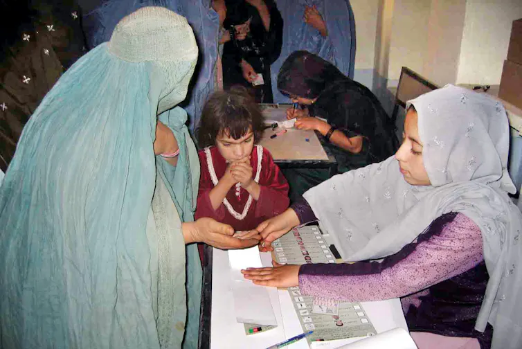 A woman casts her vote at a polling station in Kandahar.