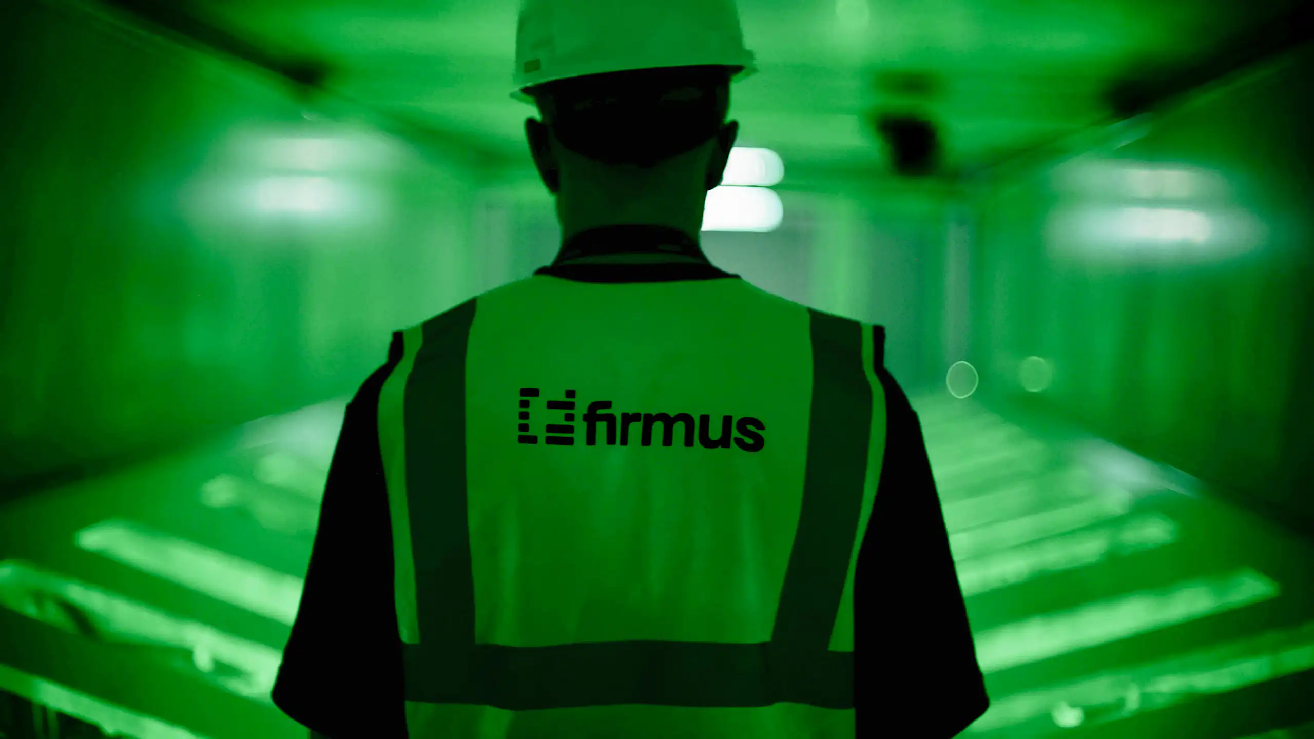 A man in a Firmus high vis vest and helmet