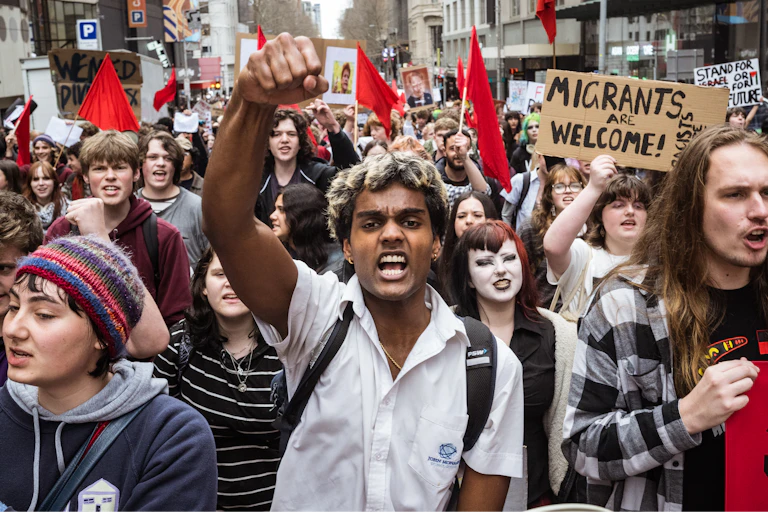 A group of young people marching in protest on a city street